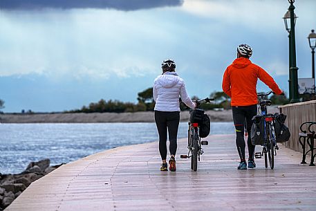 Cyclists walking on the seafront.