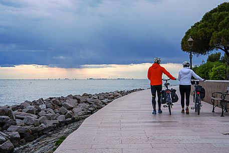 Cyclists walking on the seafront.