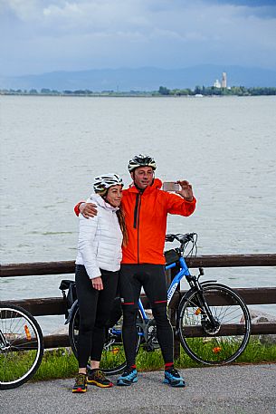 Cyclists taking a selfie with Barbana Island in the background.