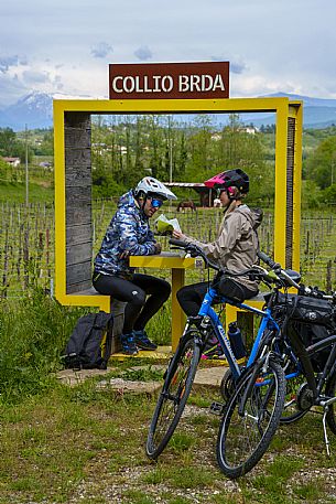 Cyclists sitting at the Collio Brda window look at the map.