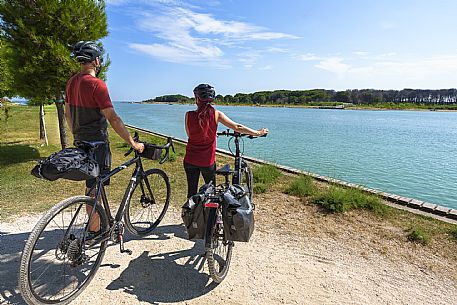 Cyclists looking at the Tagliamento river.