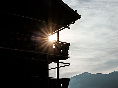 Backlit on typical Sauris chalet in winter in Sauris di Sotto