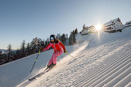 Alpine ski action with a skier woman  at Di Prampero slope on Lussari Mount.