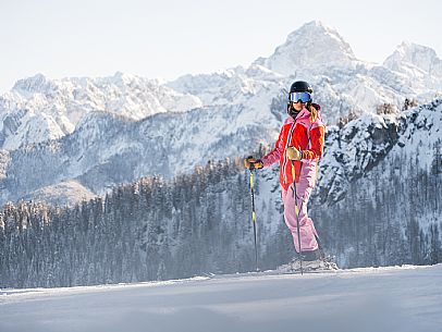 Alpine ski with joung skier woman. Di Prampero slope on Lussari Mount.