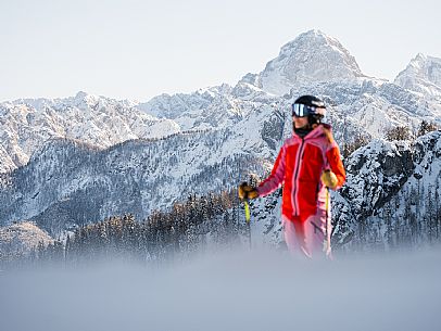 Alpine ski with joung skier woman. Di Prampero slope on Lussari Mount.