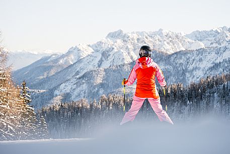 Alpine ski with joung skier woman. Di Prampero slope on Lussari Mount.