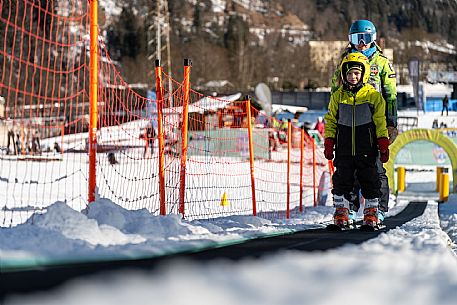 Teacher young woman and child learning alpine skiing in a school camp in Tarvisio.