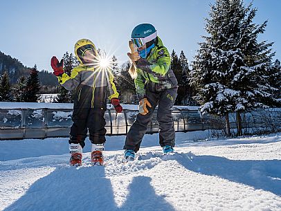 Teacher young woman and child learning alpine skiing in a school camp in Tarvisio.