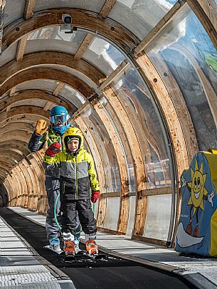 Teacher young woman and child learning alpine skiing in a school camp in Tarvisio.