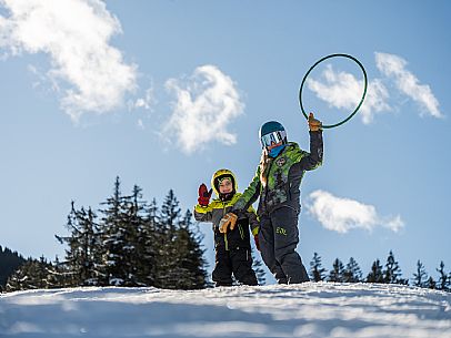 Teacher young woman and child learning alpine skiing in a school camp in Tarvisio.