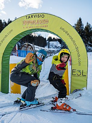 Teacher young woman and child learning alpine skiing in a school camp in Tarvisio.