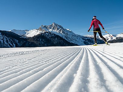 Cross-country skiing on the Plotze slope in Sauris di Sopra, with the iconic Bivera mountain in the background