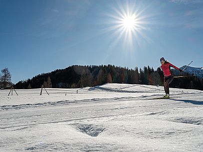 Cross-country skiing on the Plotze slope in Sauris di Sopra, with the iconic Bivera mountain in the background