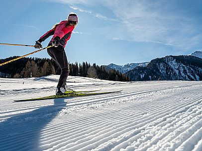 Cross-country skiing on the Plotze slope in Sauris di Sopra, with the iconic Bivera mountain in the background